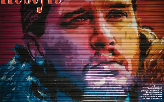  ??  ?? A picture taken yesterday shows a graffiti by street artist “Axe Colors” portraying British actor Kit Harington known for playing Jon Snow in The Game of Thrones TV series in Barcelona. — AFP photos