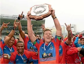  ?? PHOTO: PHOTOTEK ?? Suburbs’ captain Carl Perry hoists the Gallaher Shield for the first time in 24 years.