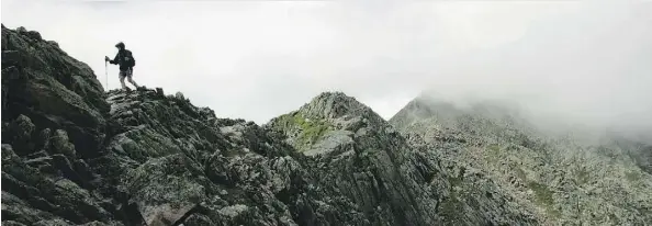  ?? ROBERT F. BUKATY/THE ASSOCIATED PRESS ?? A hiker tackles the Knife Edge, a narrow serrated ridge leading to the summit of Mount Katahdin in Baxter State Park, Maine. A newly opened monument adjacent to the park offers adventurer­s more chances explore the great outdoors.