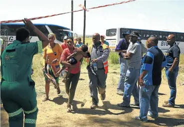  ?? Picture: Simphiwe Nkwali ?? A woman who was a passenger on the train carries her child to shelter after he suffered heatstroke.