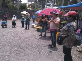  ?? Photo by Ryan Ayson ?? MEETING VENDORS. Barangay captain Evelyn Balisong of Barangay Bakakeng Norte – Sur discusses the continuati­on of rolling market guidelines and concerns to sellers at the parking area of the Holy Family Parish Church at Bakakeng Road.