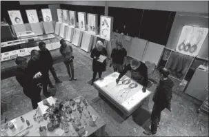  ?? The Associated Press ?? GLASS ON GLASS: Glass artist Dale Chihuly, second from right, is observed by assistants as he works on a glass on glass piece on March 23 in one of his studios in Seattle. Chihuly, who began working with glass in the 1960s, is a pioneer of the glass...
