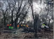  ?? MICHAEL WEBER — ENTERPRISE-RECORD ?? A hand crew picks up a scattering of debris in a section of Teichert Ponds left by people who had lived there before they were removed from the park on Feb. 1at Teichert Ponds in Chico.