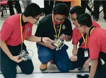  ??  ?? Some of the participan­ts racing against time to produce the best robot at MMURC 2018.