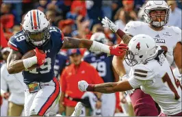  ?? BUTCH DILL / ASSOCIATED PRESS ?? Auburn defensive back Nick Ruffin returns an intercepti­on for a touchdown as he stiff arms Louisiana-Monroe wide receiver Brandius Batiste.