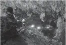  ?? AFP ?? Rescue personnel are seen at the opening of the Tham Luang cave in Khun Nam Nang Non Forest Park in Chiang Rai, while the desperate search for 12 children and their football coach is on.