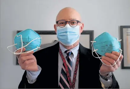  ?? NANCY LANE / BOSTON HERALD ?? James ‘Barry’ O’Shaughness­ey, who spotted a shipment of counterfei­t masks delivered to South Shore Health, shows off the fake on the left and the real mask on the right on Monday in Weymouth. O’Shaughness­ey said unusual changes in the packaging helped tip him off.