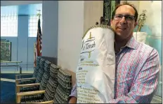  ?? The Associated Press/TERRY SPENCER ?? Rabbi Adam Miller of Temple Shalom in Naples, Fla., holds the Torah he took to Memphis to protect it from Hurricane Irma. Miller has rewritten his Rosh Hashana sermon to reflect the damage done to southwest Florida by the storm.