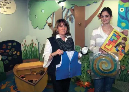  ?? ED Burke/eburke@saratogian.com ?? Children’s Museum Executive Director Michelle Smith, left, and Education Director Lindsay Carr hold items including tactile toys and a weighted vest that will be used in the autism program they are starting. The vest has a soothing effect on some...