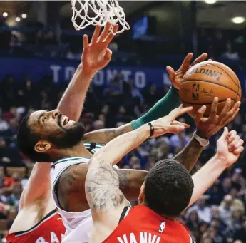  ?? CARLOS OSORIO/TORONTO STAR ?? Boston’s Kyrie Irving, centre, gets fouled by Toronto’s Fred VanVleet on a layup attempt during the first half at the Air Canada Centre on Tuesday. Irving put up 17 points while the Raptors went on to win 111-91.