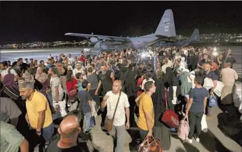  ?? Raad Adayleh Associated Press ?? JORDANIANS evacuated from Sudan arrive at a military airport in Amman. A stream of European, Mideast, African and Asian military aircraft flew in all day Sunday and Monday to ferry foreigners out of Sudan.