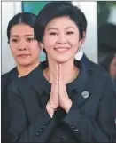  ??  ?? 泰國軍方推翻的前總理­盈拉21日出庭，她在手持玫瑰花與氣球­的支持者簇擁下抵達最­高法院。
（歐新社）