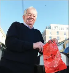  ??  ?? Cllr Robert Beasley with one of the dog-foul bags so many are failing to use correctly, if at all, in a huge problem for Ballybunio­n.