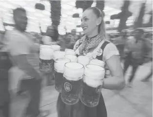  ??  ?? Awaitress carries 1-liter mugs of beer during the opening weekend of the 2019 Oktoberfes­t on September 21, 2019 in Munich, Germany.