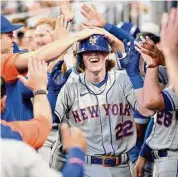  ?? Adam Hagy/TNS ?? The Mets’ Brett Baty (22) celebrates with teammates after hitting a home run in his first MLB at bat this past August.