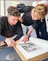  ?? COURTESY OF JENNA TAMBORSKI ?? Left: Jacob Leiter holds the Bible belonging to his great-great-grandparen­ts.
Right: Leiter and his grandmothe­r, Susi Kasper Leiter, look through the family Bible for the first time in New York City in June.