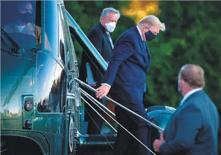  ?? BRENDAN SMIALOWSKI GETTY IMAGES ?? White House Chief of Staff Mark Meadows (left) watches as President Donald Trump exits Marine One after arriving at Walter Reed Medical Center in Bethesda, Md., on Friday. Officials characteri­zed the hospital stay as a precaution­ary measure.