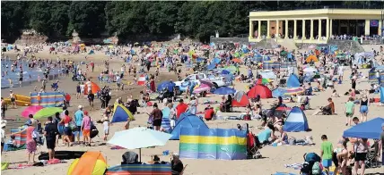  ?? WALES NEWS SERVICE ?? People enjoying the hot weather last week at Whitmore Bay, Barry