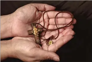  ??  ?? LUPE TORRES holds a necklace her father was wearing when he died in January in the COVID-19 unit at Foothill Presbyteri­an Hospital. He died two weeks before his 71st birthday.