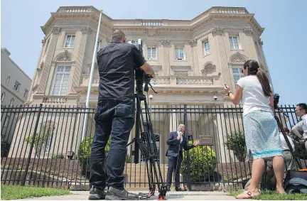  ?? JACQUELYN MARTIN/THE ASSOCIATED PRESS ?? Telemundo news anchor Fausto Malave reports in front of the Cuban Interests Section, which serves as the diplomatic mission of Cuba to the U.S. in Washington. President Barack Obama said Wednesday the U.S. and Cuba will reopen their embassies.