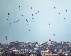  ?? LEO CORREA/ASSOCIATED PRESS ?? Supplies are dropped by parachutes into the northern Gaza Strip, as seen from southern Israel, on Friday.