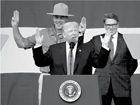  ?? Associated Press ?? n President Donald Trump, front left, gestures Monday as Interior Secretary Ryan Zinke, left, and Energy Secretary Rick Perry, both former Boy Scouts, watch at the 2017 National Boy Scout Jamboree at the Summit in Glen Jean, W.Va.