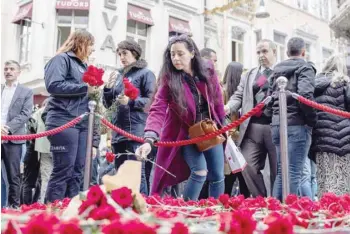  ?? — Reuters ?? People lay flowers to pay tribute to the victims of a Sunday’s blast that took place on Istiklal Avenue, a popular spot for shoppers and tourists, in Istanbul, Turkey, on Monday.