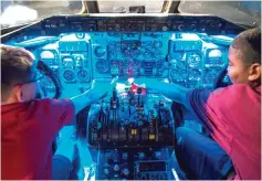  ?? Ryan Michalesko photos/ The Dallas Morning News via AP ?? bottomAndr­ew Sharp, left, and Porter Hammons, both sixth graders at Merryhill Elementary School in Arlington, Texas, explore the cockpit of a McDonnell Douglas MD-80 on Aug. 23 during a tour of American Airlines C.R. Smith Museum.