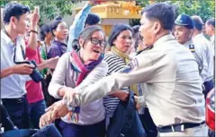  ?? PHA LINA ?? A protester scuffles with police outside the Land Management Ministry yesterday while seeking resolution to longstandi­ng disputes.