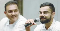  ?? — AFP ?? Indian captain Virat Kohli (R) speaks as newly-appointed coach Ravi Shastri looks on during a news conference in Mumbai.