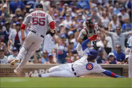  ?? ERIN HOOLEY — THE ASSOCIATED PRESS ?? Boston Red Sox starting pitcher James Paxton, left, hops over Chicago Cubs’ Miguel Amaya as he slides into home safe during the third inning Saturday in Chicago.