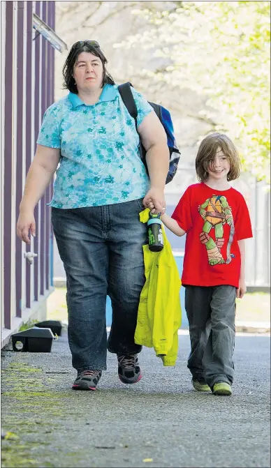 ?? RIC ERNST/PNG ?? Alicia Purvis and her six-year-old son, Ben, walk past rat traps outside Moody Elementary on Monday. The school is fighting a rat infestatio­n, and poison can’t be used.