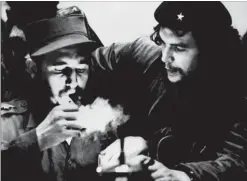  ??  ?? This file photo taken in the 1960s shows Castro (left) lighting a cigar while listening to Argentinia­n revolution­ary Ernesto Che Guevara.