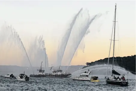  ?? Photos by Eric Risberg / Associated Press ?? The San Francisco Fire Department’s fireboat Phoenix sprays water in Belvedere Cove during a memorial flotilla Saturday.