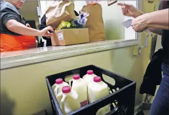  ?? [FRED SQUILLANTE/ DISPATCH] ?? Fresh milk — usually scarce at the Holy Family Church food pantry in Franklinto­n — is suddenly plentiful there and at other pantries.