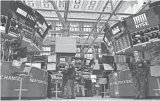  ?? DREW ANGERER, GETTY IMAGES ?? Traders work at the New York Stock Exchange on March 27.