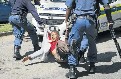  ?? Picture: JOSHUA STEIN/OPPIDAN PRESS ?? CRACKDOWN: A student is hauled off by police outside Rhodes University in Grahamstow­n this week