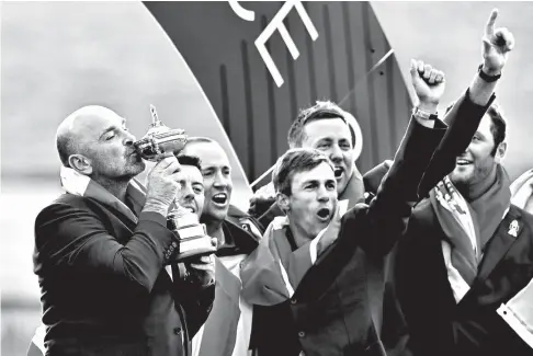  ?? AP ?? SEALED WITH A KISS. Europe team captain Thomas Bjorn kisses the cup as he celebrates with his players after the European team won the 2018 Ryder Cup golf tournament at Le Golf National in Saint Quentin-en-Yvelines, outside Paris, France, Sunday, Sept. 30, 2018.