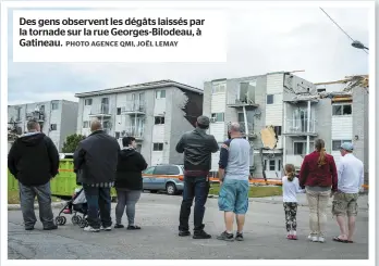  ?? PHOTO AGENCE QMI, JOËL LEMAY ?? Des gens observent les dégâts laissés par la tornade sur la rue Georges-Bilodeau, à Gatineau.