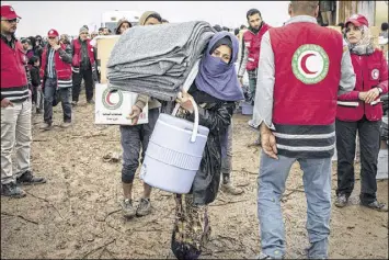  ?? CENGIZ YAR / AP ?? Iraqis displaced from Mosul receive aid near Qayara on Wednesday. Iraqi military leaders say they will soon launch an offensive against militants in Mosul.