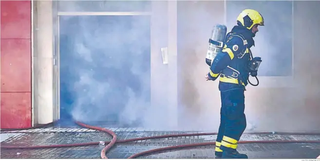  ?? JULIO GONZÁLEZ ?? El humo sale por el portal de un edificio afectado por el fuego tras inundar la escalera de la finca.
