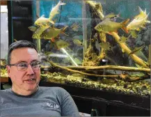  ?? MARSHALL GORBY / STAFF ?? David Ratay, owner of Aquascapes Custom Aquarium Sales, talks about his business with fish watching.