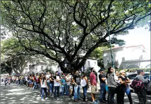  ?? AP/ARIANA CUBILLOS ?? People line up to cast their ballots at a polling station in Caracas, Venezuela, during a symbolic referendum against rewriting the nation’s constituti­on.