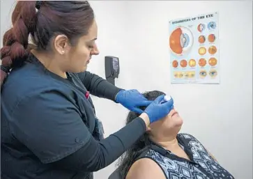  ?? Photograph­s by David McNew For The Times ?? MEDICAL assistant Silvia Fletes prepares Rosa Guzman for a retinal test at a clinic in Boyle Heights within hours of her diabetes diagnosis. Her doctors can track her referrals through the county’s eConsult portal.