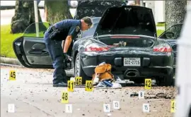  ?? Michael Ciaglo/Houston Chronicle via AP ?? A police officer investigat­es a car belonging to lawyer Nathan DeSai, who is believed to have shot at least six people before he was killed by police Monday in Houston.