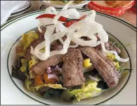  ?? Arkansas Democrat-Gazette/ERIC E. HARRISON ?? Rice noodles top the Thai Beef Salad at Atlas Bar, which features sliced beef, lettuce, cilantro, Thai basil and mint with cucumber, tomatoes and peanuts.