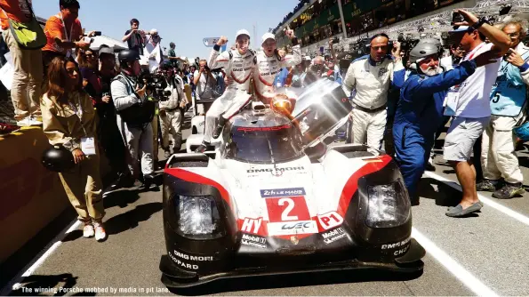  ??  ?? The winning Porsche mobbed by media in pit lane.