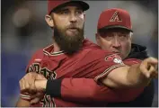  ?? JIM RASSOL — THE ASSOCIATED PRESS ?? Diamondbac­ks pitcher Madison Bumgarner is restrained by bench coach Jeff Banister while arguing with umpires.