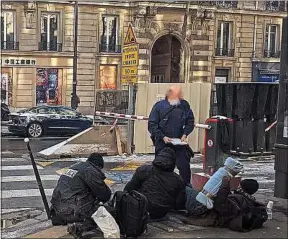  ??  ?? Les policiers de la Bapsa viennent en aide à des SDF, boulevard Haussmann.