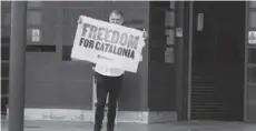  ??  ?? Catalan leader Jordi Cuixart holds a banner in front of the Lledoners prison in Sant Joan de Vilatorrad­a, Spain, after the Spanish government announced a pardon for those who participat­ed in Catalonia’s failed 2017 independen­ce bid.